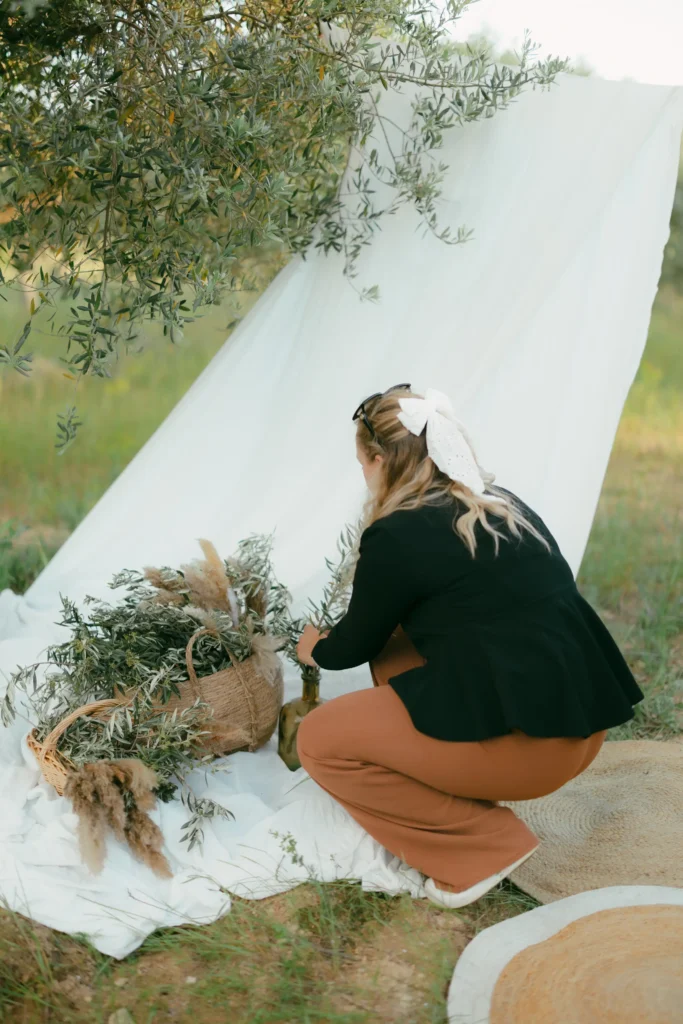 photo de Jennifer, décoratrice de mariage à aix en provence, metant en place une décoration champêtre aec des branches d'olivier